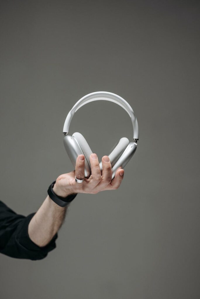 hand holding a white wireless headphones