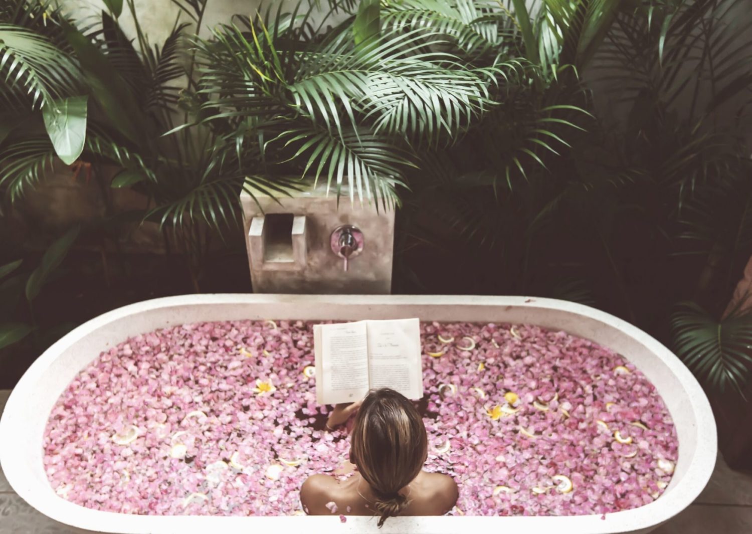 woman in a bath of pink flowers