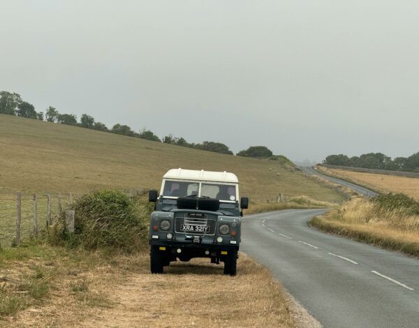 vintage land rover on countryside road