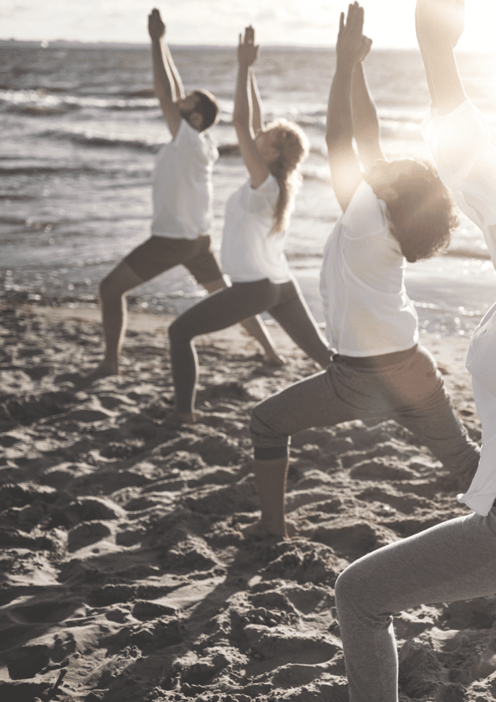 women doing yoga on the beach