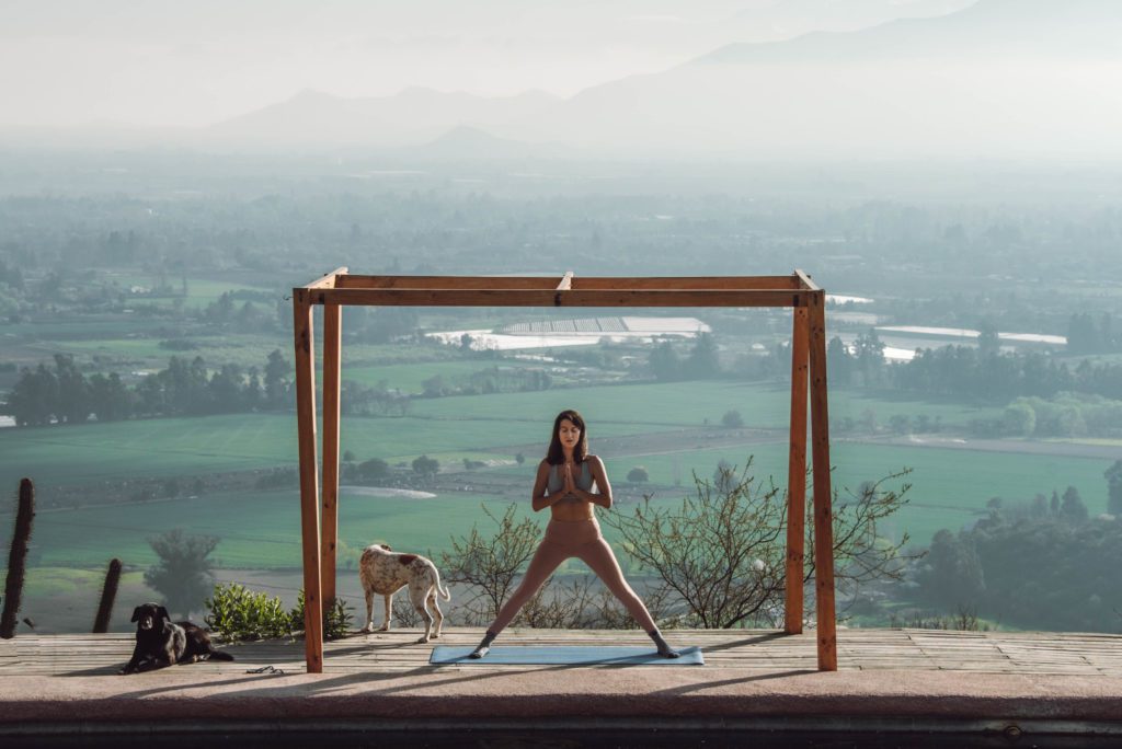 woman doing yoga on a deck with a view