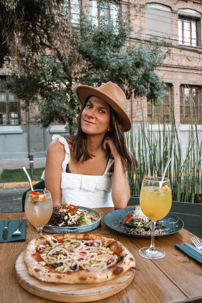 woman in a restaurant enjoying vegan Pizza and Drinks