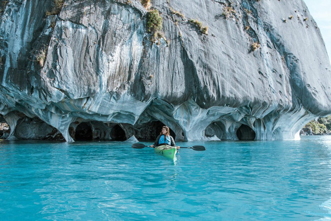 woman kayaking in the Marble Caves pinterest pin