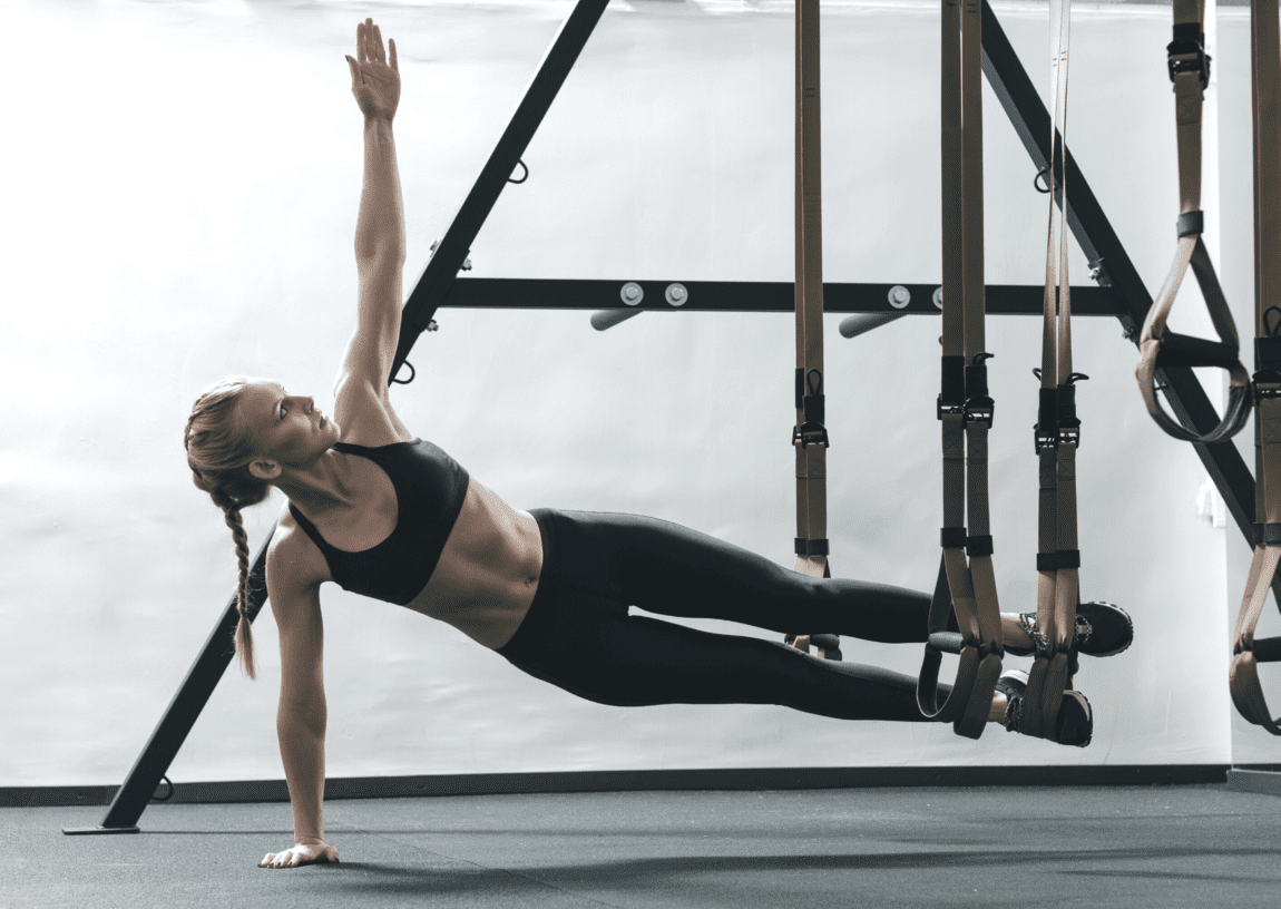 women working out with TRX- best portable exercise equipment