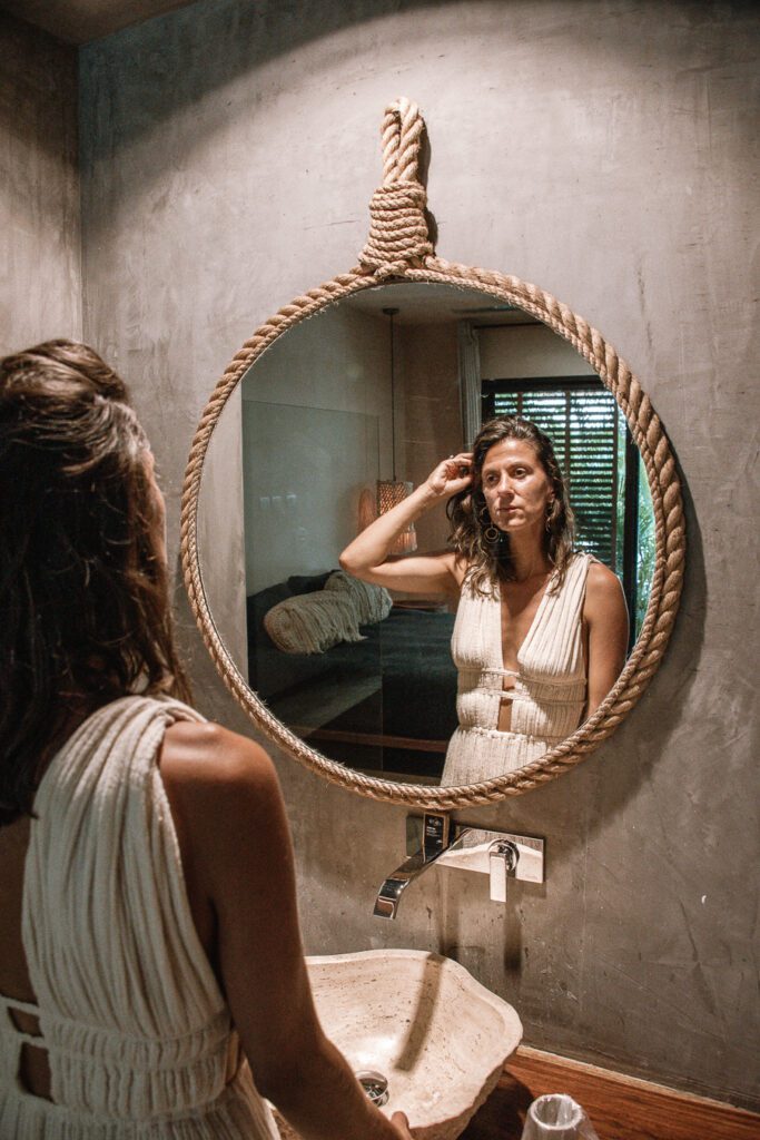 Woman looking into hotel mirror