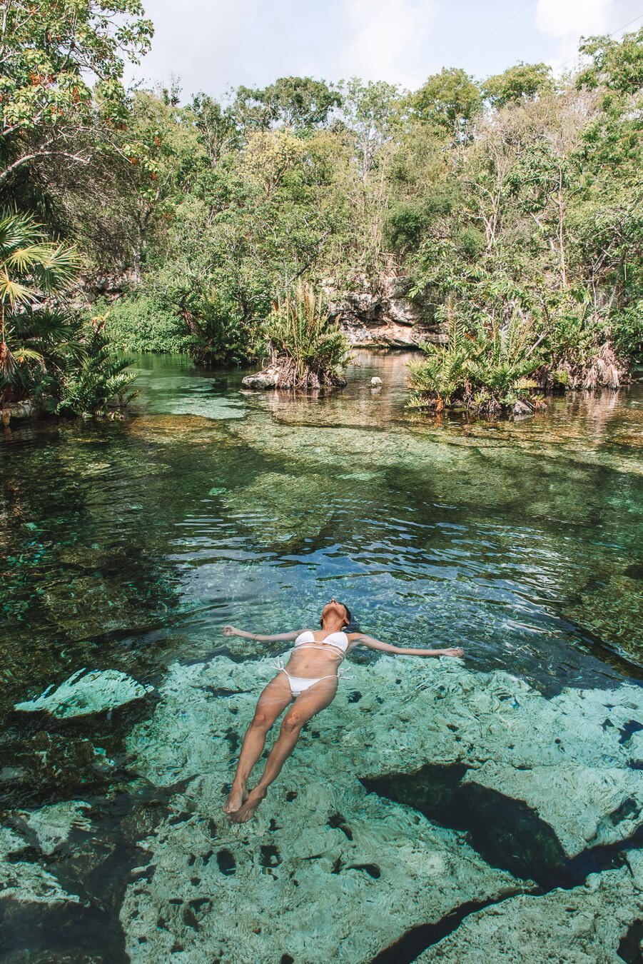 woman floating in cenotes azul