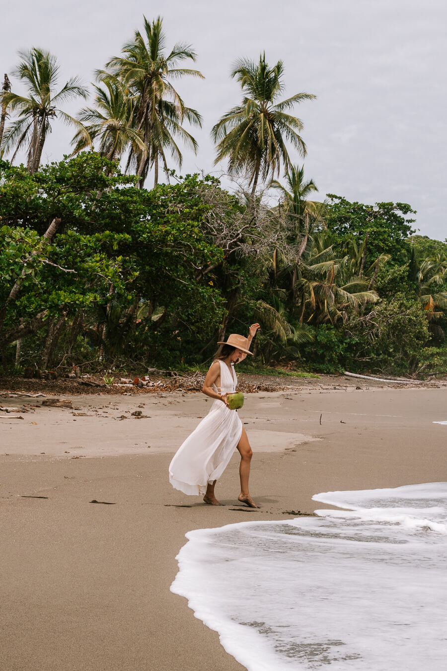 woman with a coconut in a dress in Costa Rica Caribbean beaches