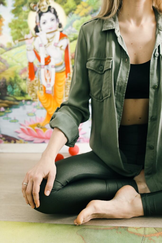 a woman in green jacket doing yoga