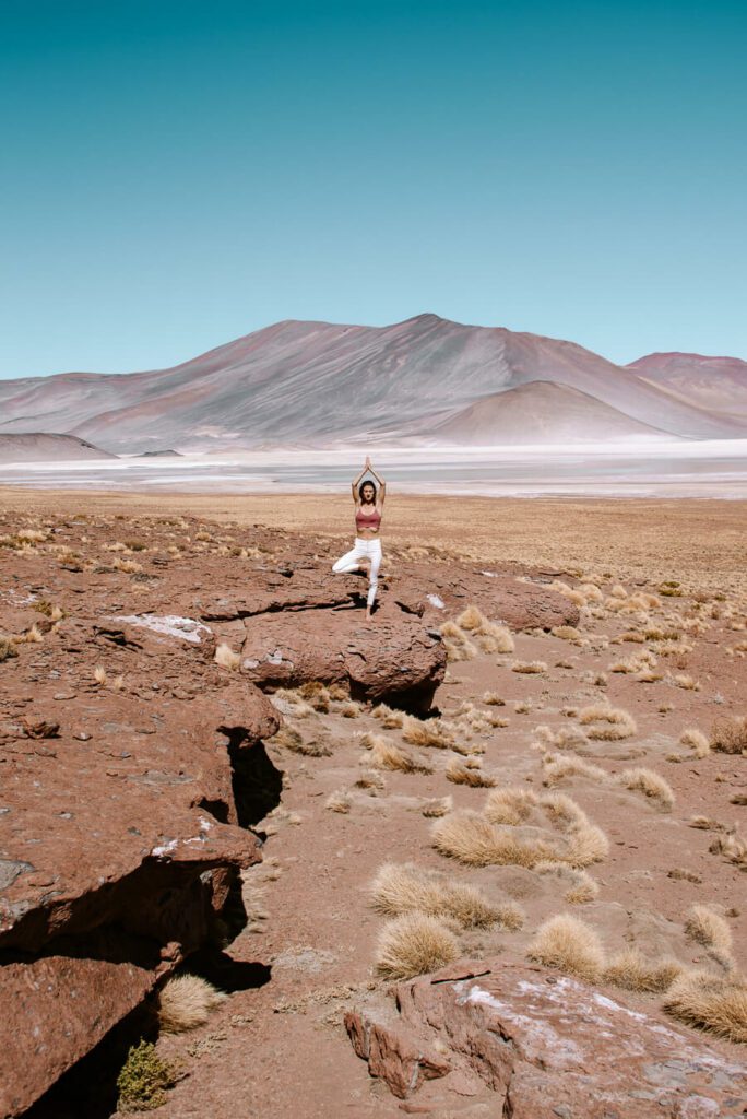 woman doing yoga at the Red rocks Atacama Desert Chile