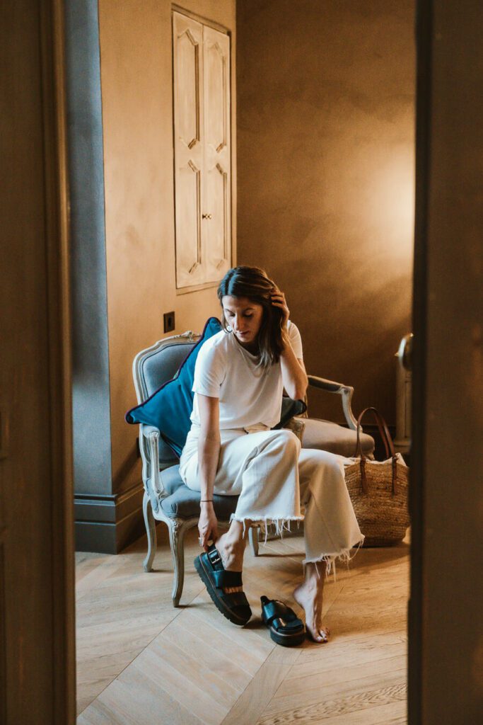 woman putting on shoes in a hotel room in Ostuni, Italy