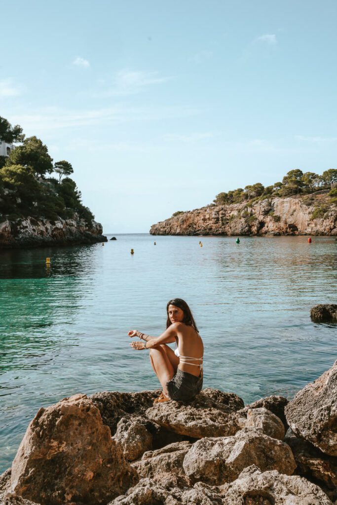 woman sitting on the rocks in Cala Pi, Mallorca