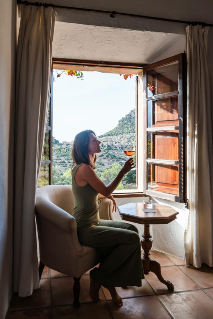 woman drinking wine in a window in Mallorca Spain