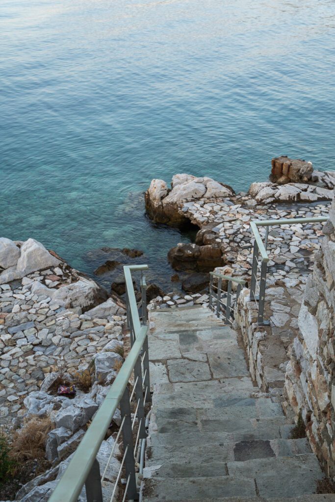 stairs leading down to the clear sea in Skiathos Greece