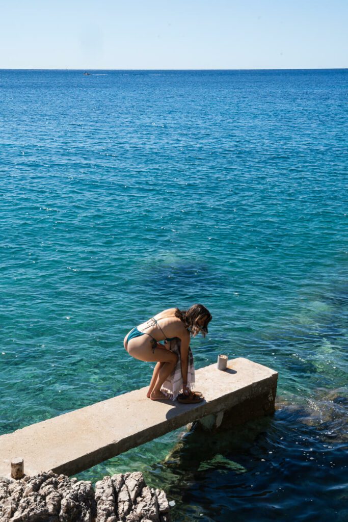 woman at a pier on a beach cove in Hvar Croatia