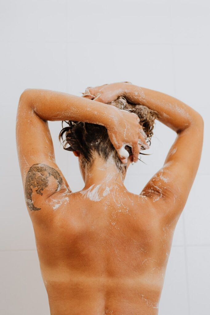 woman washing her hair with natural shampoo for greasy hair