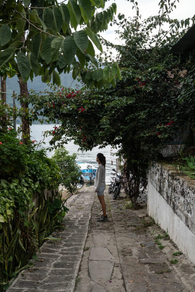 woman walking down a lakeside path in san pedro la laguna