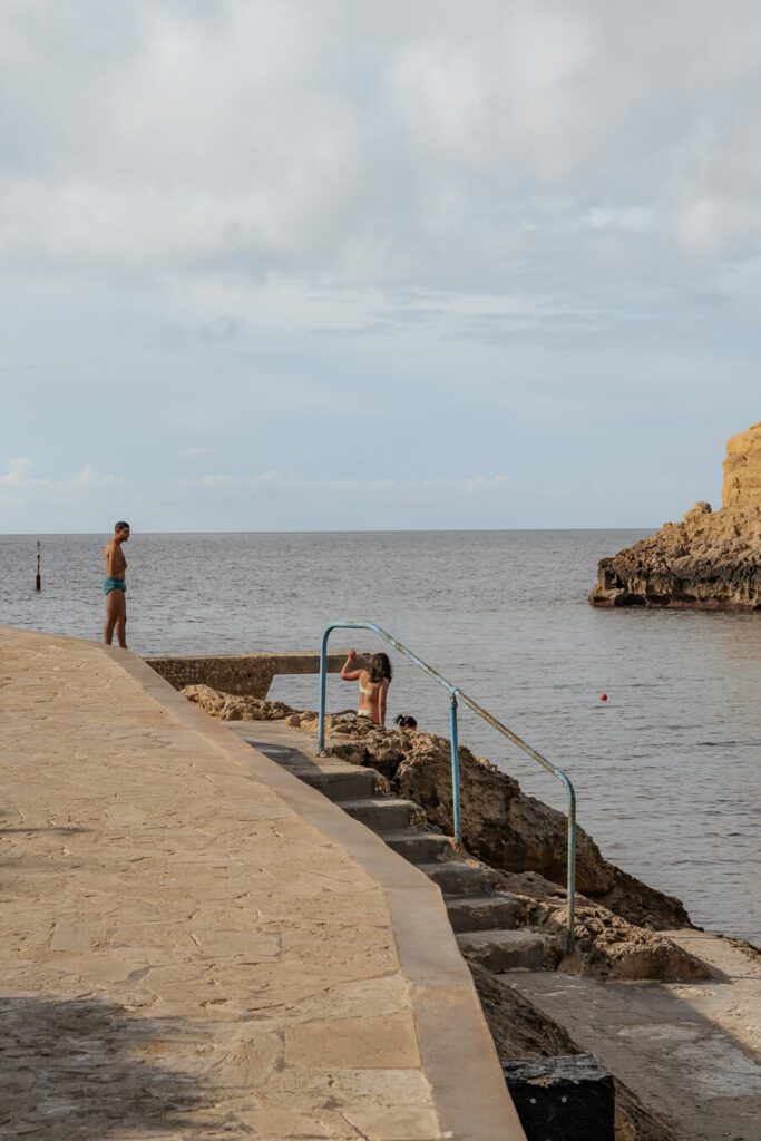 people swimming and diving in Xlendi, Gozo