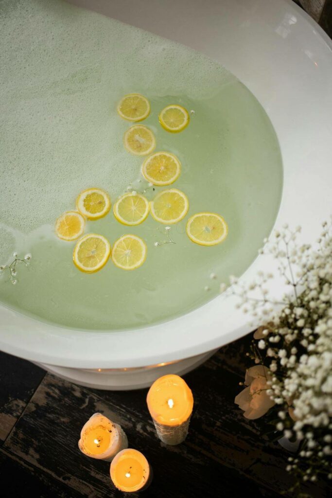 bath with candles and lemon slices in spa