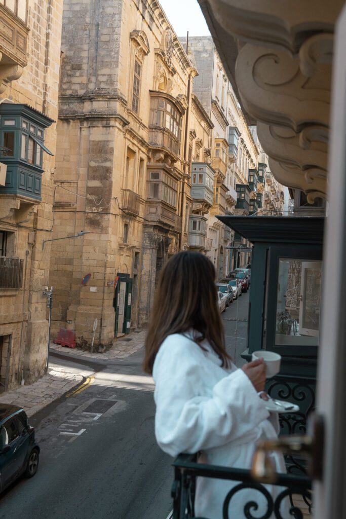 woman having coffee on a boutique hotel balcony in Valletta, Malta