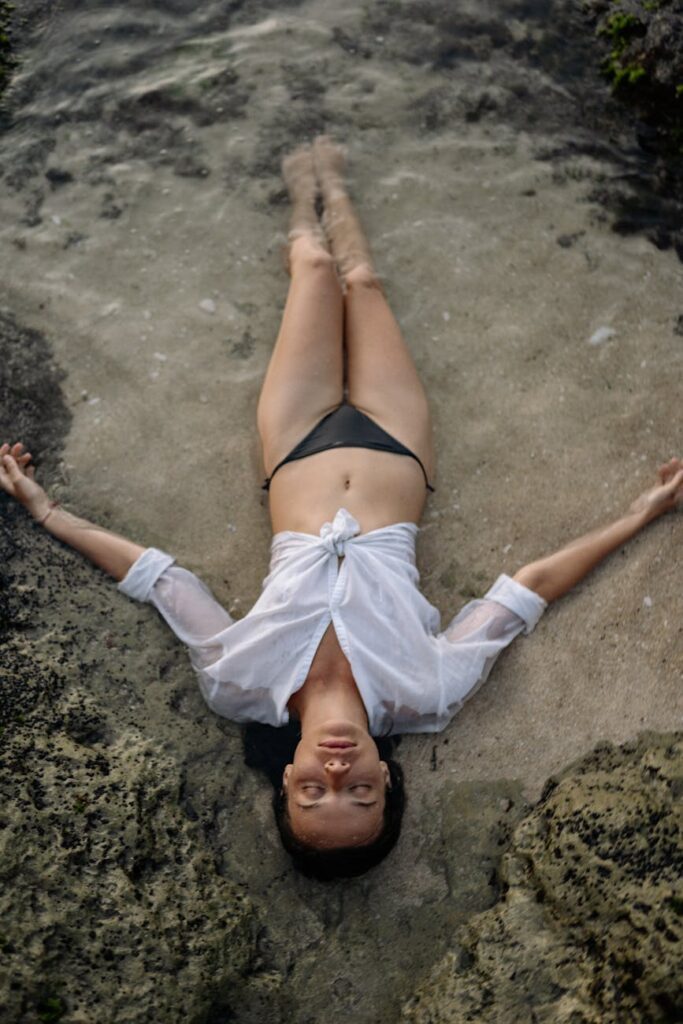young woman lying in shirt and bikini in sea water