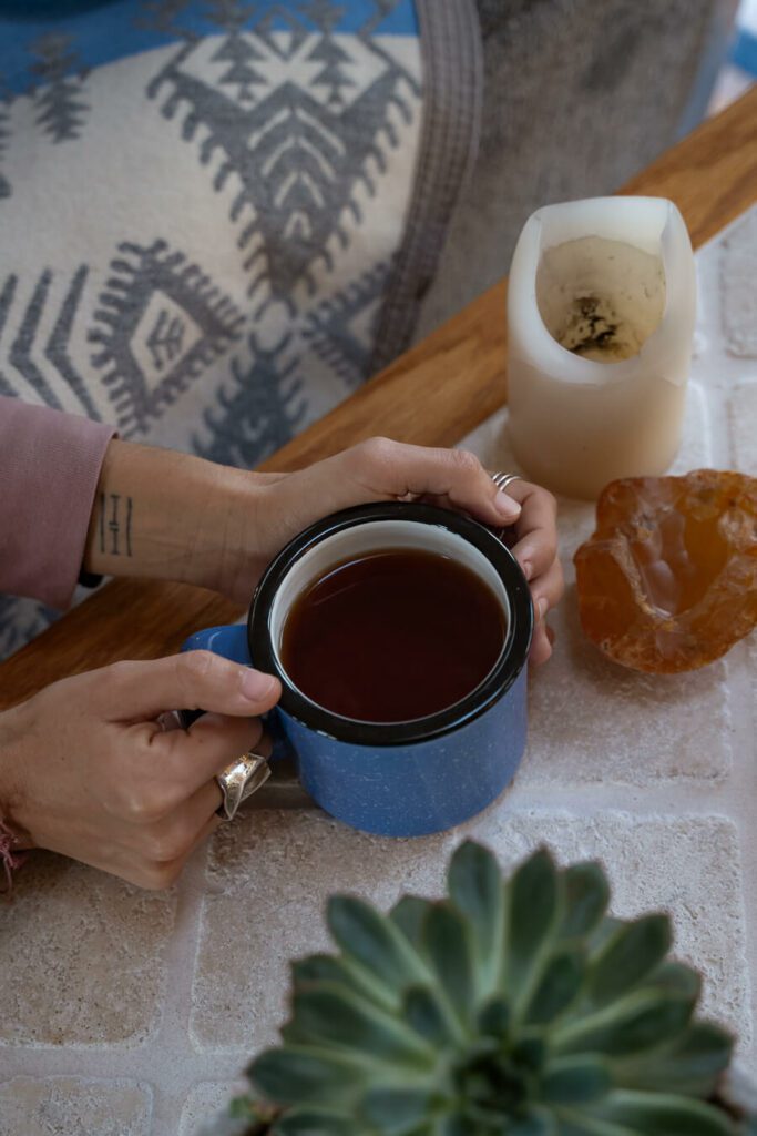 hands cradling a hot cup of tea