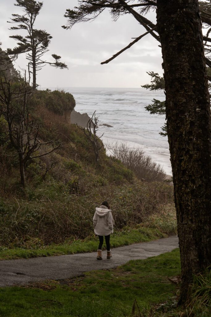 woman walking down to a beach in Oregon