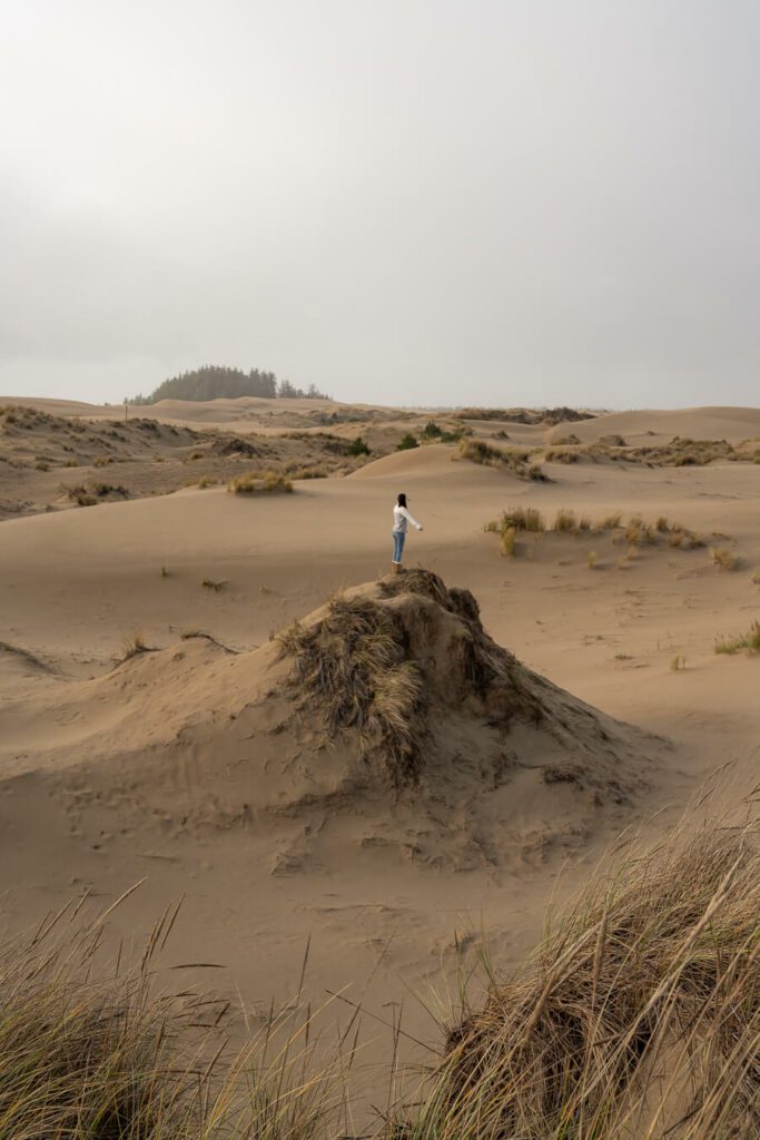 woman standing on a dune at the oregon dunes state park