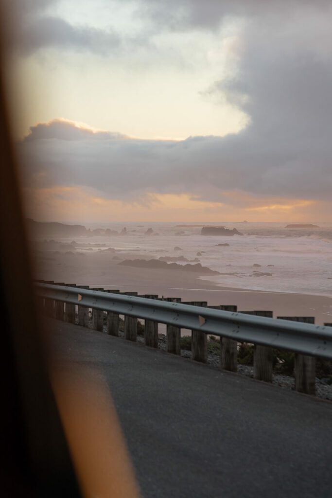 view of of the car to the sunset on the oegon coast, driving between oregon coast towns