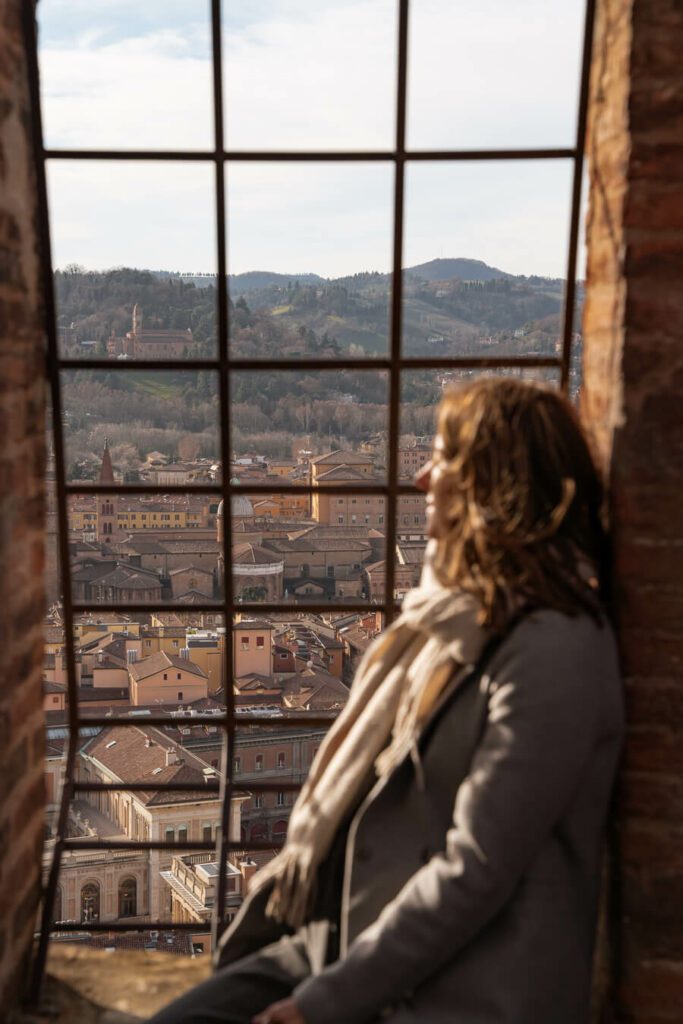 woman looking out at the view from the top of the Asinelli Tower