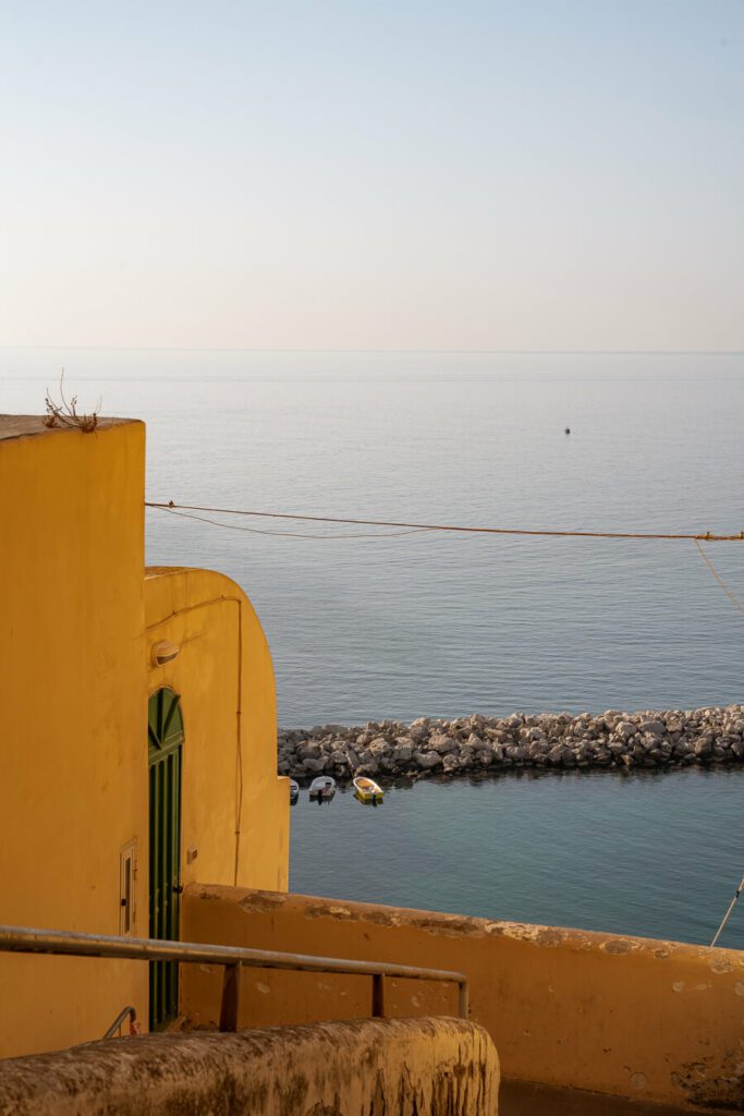 yellow building and calm sea in procida