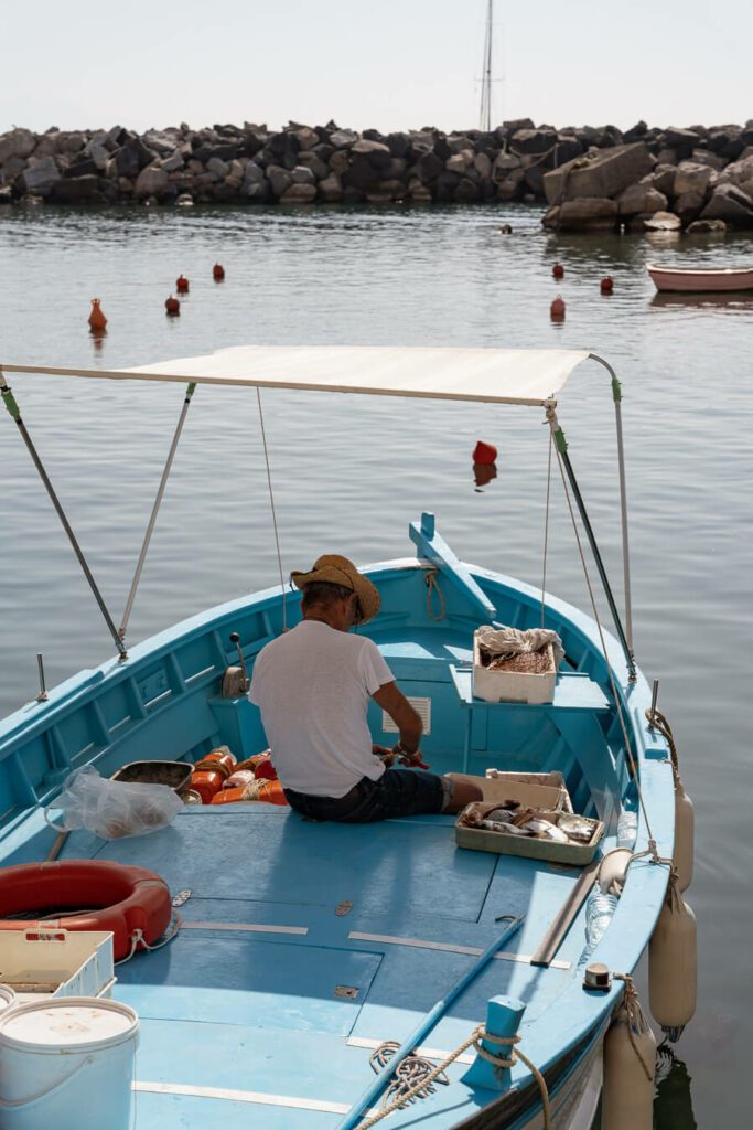 fisherman in his boat in procida italy