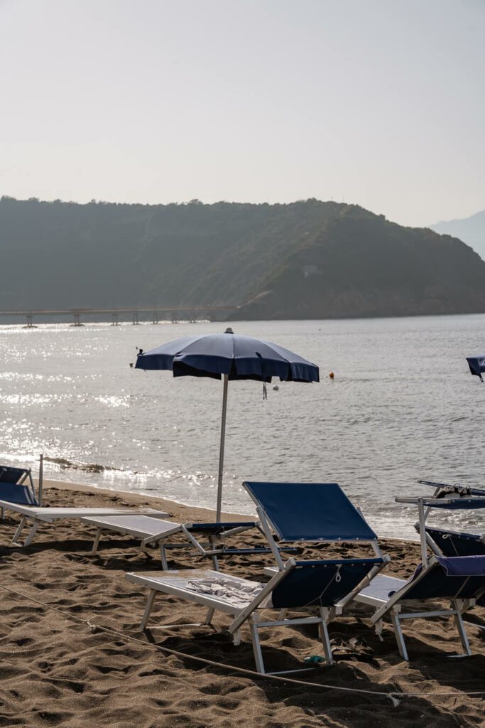 sun loungers and umbrella on the beach in procida