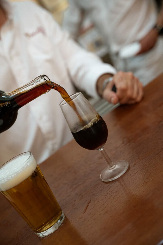 barman pouring a class of orange wine in seville