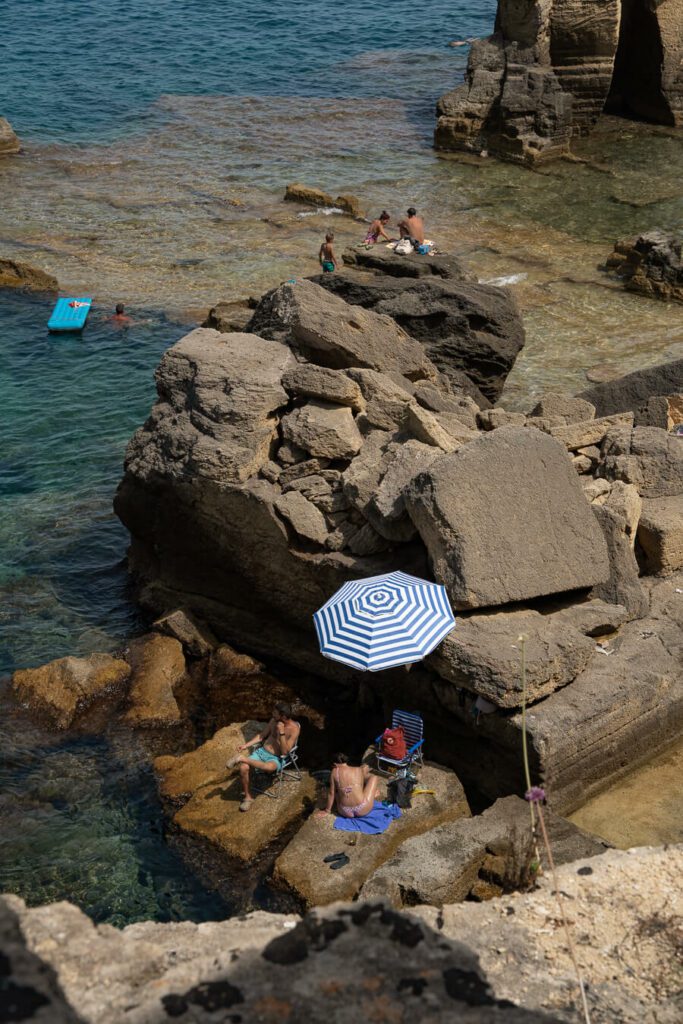 bathers on the rocks at bagno marino archi