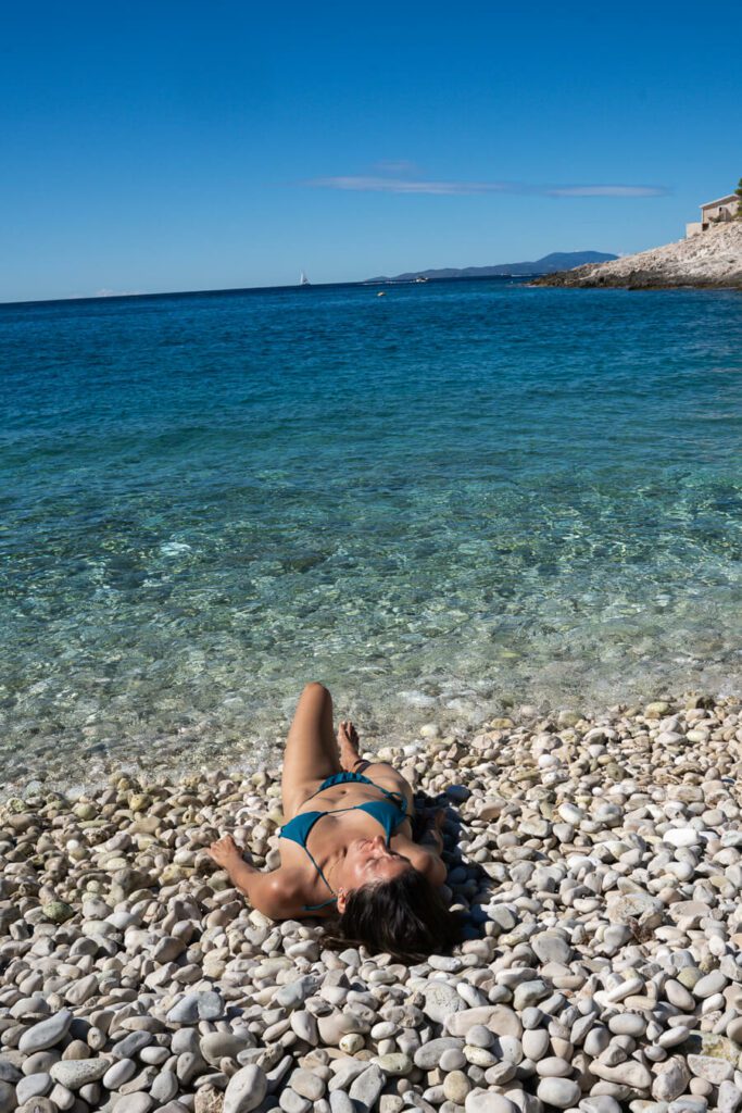 woman, me lying on a pebble beach in hvar croatia