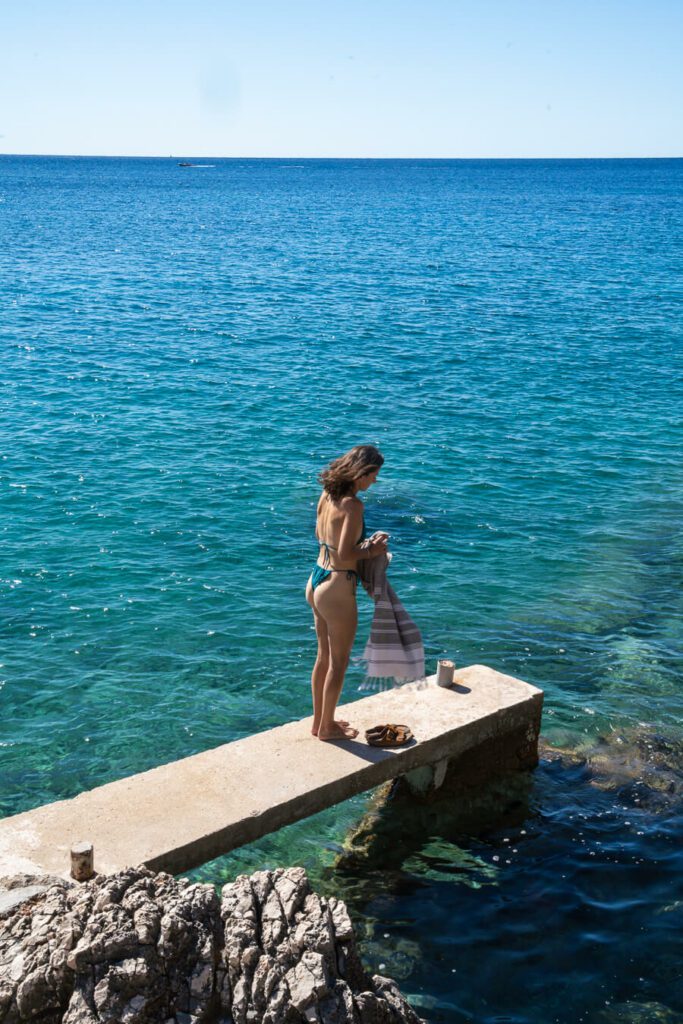 woman, me on a small pier on a beach on hvar croatia