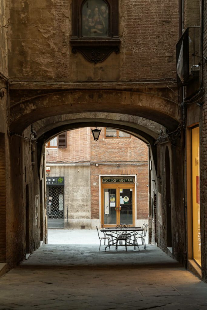 restaurant table in medeival alleyway in siena