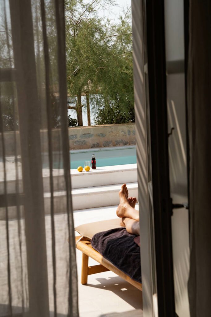 man relaxing on terrace in his room in hydra