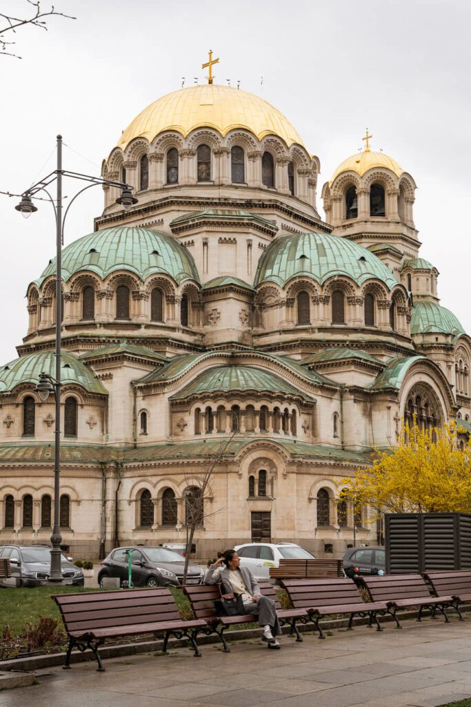 woman, me on a bench with Alexander Nevsky cathedral.